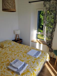 布雷斯特Maison de Kerangall的一间卧室配有一张床,上面有两条毛巾