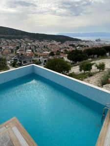 切什梅Nova Butik Hotel Çeşme的蓝色游泳池,享有城市美景