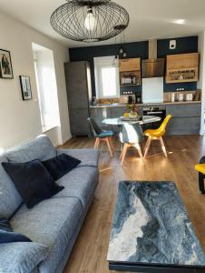 布雷斯特Maison de Kerangall的一间带蓝色沙发的客厅和一间厨房