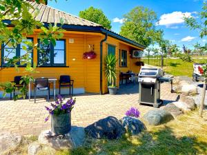 SolliSarpsborg Apartments - Utne Camping的前面有烤架的小黄色房子