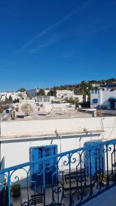 Dar Mimoun BeyLe Superbe - Sidi Bou Saïd的阳台设有蓝色椅子,享有城市美景。