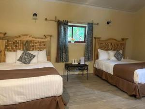 CosaláHotel Quinta Minera的酒店客房设有两张床和窗户。