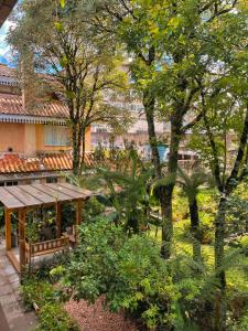 卡内拉达斯阿罗卡里亚斯旅馆的一座花园,在一座建筑前方,花园内种有长凳和树木