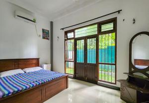 米瑞莎Дом на Шри Ланке的一间卧室设有一张床和一个大窗户