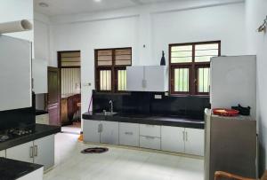 米瑞莎Дом на Шри Ланке的厨房配有白色橱柜和黑色台面