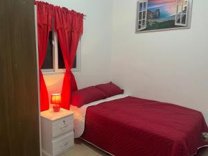 圣安娜Dream of angels home的一间卧室设有红色的床和窗户。