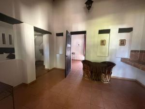 CosaláHotel Quinta Minera的一间设有桌子的房间和一间带走廊的房间