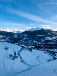 普拉托·阿罗·斯泰尔维奥Egghof的一座有雪覆盖的山丘,背景是群山