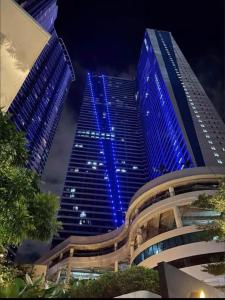 马尼拉Air Residences in the Heart of Makati City - Great for Tourists, Staycations or Working Professionals的一座高大的建筑,晚上有蓝色的灯光