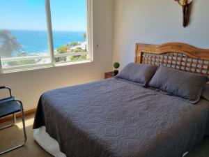 瓦尔帕莱索Departamento Frente Playa las Torpederas的一间卧室设有一张床,享有海景