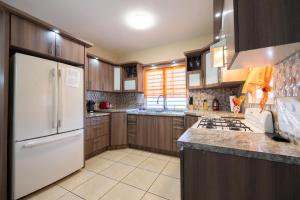 伊莎贝拉Arenales Vacational House的厨房配有木制橱柜和白色冰箱。