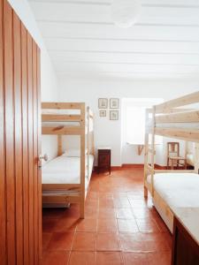 Quinta da CascalheirinhaMonte Alto da Guerra的客房设有两张双层床,铺有瓷砖地板。