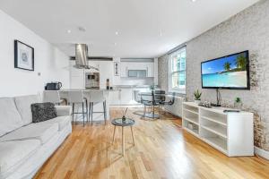 伦敦2BR flat next to London Eye on lower marsh 96A的一间带白色沙发的客厅和一间厨房