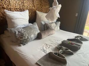 马布拉Luna Piena 19A Zebula golf course and spa resort的一张带两条毛巾和枕头的床