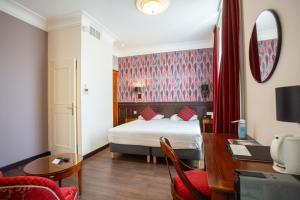 布尔日Best Western Plus Hôtel D'Angleterre的一间酒店客房,一间设有一张床和一张书桌