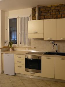 普拉托CASA SANGALLO的厨房配有白色橱柜和炉灶烤箱。