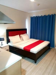 马尼拉Sab R. Bel air soho的一间卧室配有一张带红色和蓝色窗帘的床