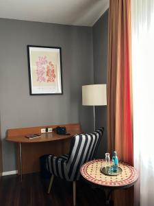 多特蒙德安姆比恩特酒店的酒店客房配有书桌、椅子和桌子。