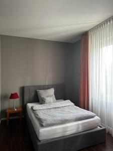 多特蒙德安姆比恩特酒店的卧室内的一张床位,卧室内配有窗户和桌子