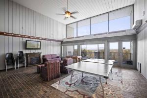 拉科尼亚Cute Cedar Lodge Studio with Balcony & Lake Views!的客厅配有乒乓球桌和椅子