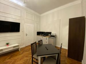 克拉科夫ROYAL Apartments的一间带桌椅的用餐室和一间厨房