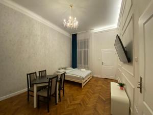 克拉科夫ROYAL Apartments的一间带桌子、床和电视的用餐室