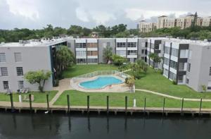 劳德代尔堡Designer River View Apartments的公寓大楼设有毗邻水面的游泳池