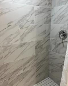 劳德代尔堡Designer River View Apartments的浴室设有大理石瓷砖和淋浴。