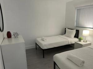 劳德代尔堡Designer River View Apartments的白色的客房配有两张床和一张沙发