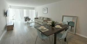 劳德代尔堡Designer River View Apartments的客厅配有桌椅和沙发