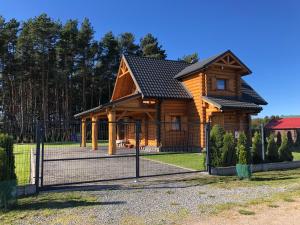 卡文斯基波托皮耶弗采Dom Wakacyjny z bali 'Złoto Północy'的小木屋前方设有围栏