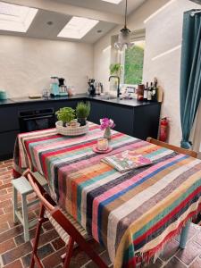 斯容代克Little Secret Zeeland + ligbad的厨房里配有一张桌子,上面有五颜六色的毯子