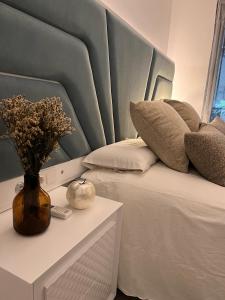 锡蒂奥卡拉翁达Apartamento Mi Capricho的一张带蓝色床头板和花瓶的床