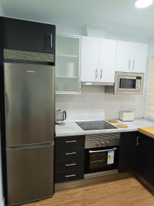 圣克鲁斯-德特内里费Apartamento Meraki的厨房配有不锈钢冰箱和白色橱柜