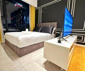 吉隆坡Axon Residence By Perkasa Suites的一间卧室配有一张床和一张书桌及电视