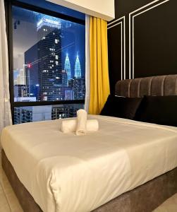 吉隆坡Axon Residence By Perkasa Suites的一间配备有一张白色大床的卧室,享有城市美景。