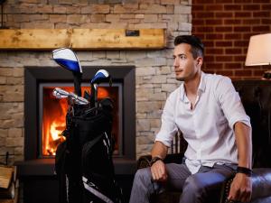 卡罗维发利Cihelny Golf & Wellness Resort的坐在摩托车旁椅子上的男人