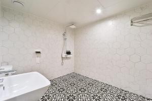 首尔吉姆斯汤姆吉酒店的浴室配有白色浴缸和水槽