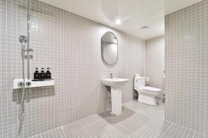 首尔吉姆斯汤姆吉酒店的一间带卫生间、水槽和镜子的浴室