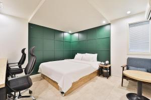 首尔吉姆斯汤姆吉酒店的卧室配有一张床、一张桌子和椅子