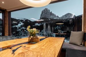 圣克里斯蒂娜Enjoy Dolomites - Chalet的一间带桌子和大窗户的用餐室