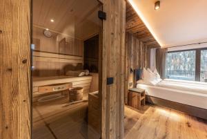 圣克里斯蒂娜Enjoy Dolomites - Chalet的小屋设有卧室、床和窗户