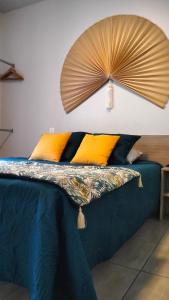 罗纳河畔的图尔农Tikazéla - Escale Tournon-Sur-Rhône的卧室配有一张床铺,墙上装有风扇