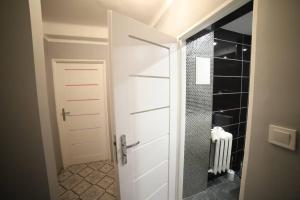 科沙林Mieszkanie osiedle Północ的浴室设有白色门和步入式淋浴间。