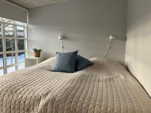 维斯特罗哈文GuestHouse Læsø的一间卧室配有一张带蓝色枕头的大床