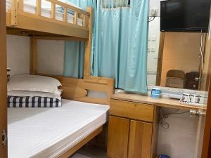 香港中信宾馆的一间卧室配有双层床和一张书桌及电视