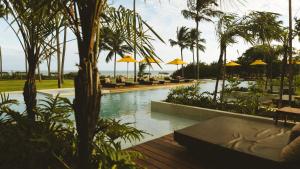 圣米格尔-杜斯米拉格里斯Mahré Hotel & Spa的度假村内带椅子和遮阳伞的游泳池