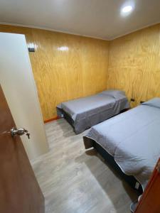 奥索尔诺Arriendo de cabaña centro osorno的小房间设有两张床和一扇门