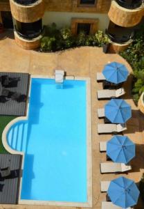 吉达EWG Golden Sea Hotel Obhur的享有带蓝伞的游泳池的顶部景致