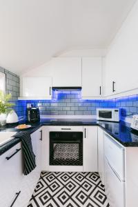 卡迪夫Central Retreat的厨房配有白色橱柜和蓝色瓷砖